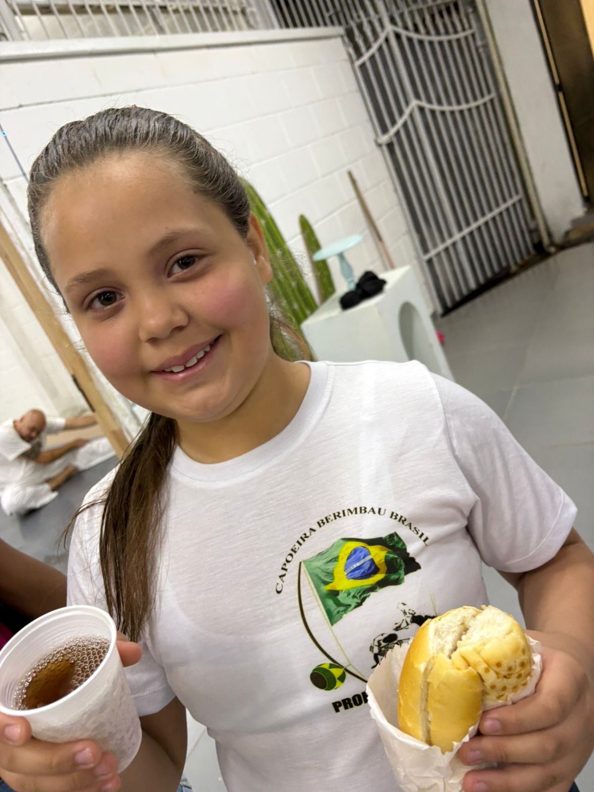 Participante do projeto Capoeira do MIDE com a camiseta do projeto